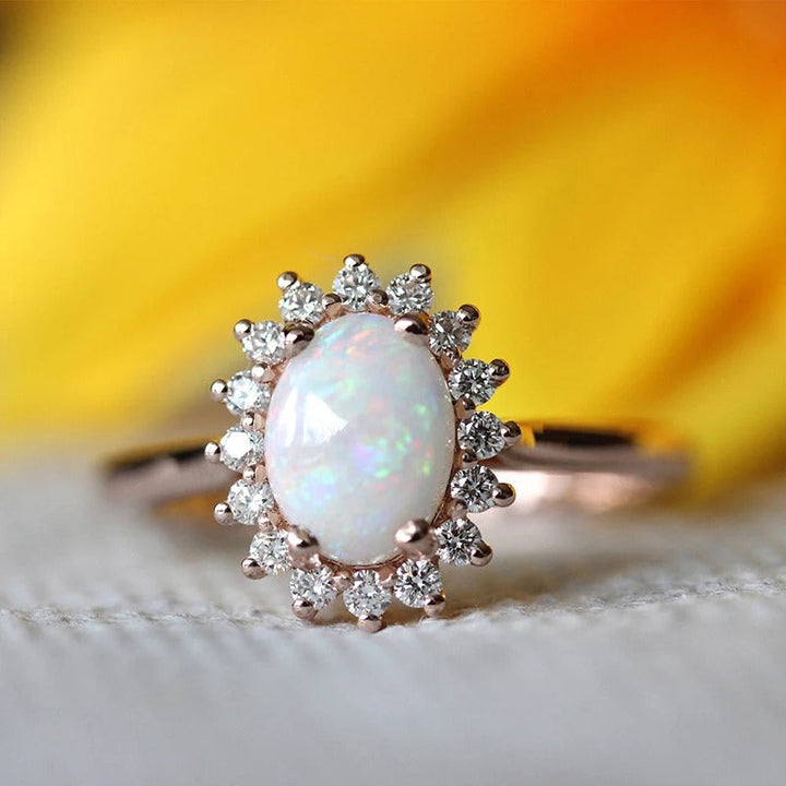 Bague vintage en or rose avec opale ovale et bordure en cristal éclatant